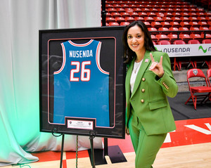Michelle Dearholt in front of a UNM basketball jersey that says Nusenda