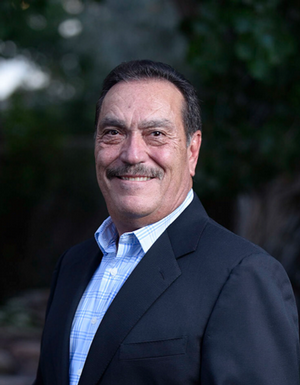 Stephen Griego in a striped blue button up with a navy blue jacket. 