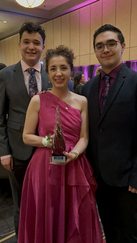 Roberta Rivera pictured in the middle with her sons holding her Women Who Mean Business award. 