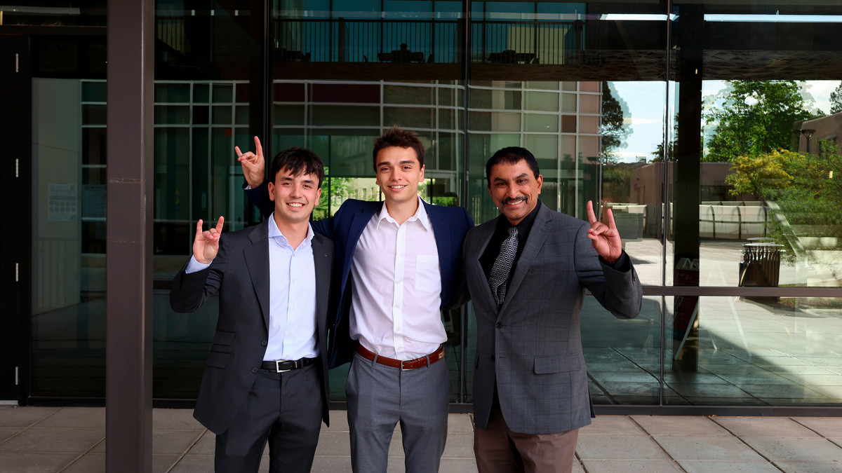 Image of David Davila, Samuel Landis, and Professor Subramanian Iyer doing a lobo pose in front of the McKinnon Center for Management