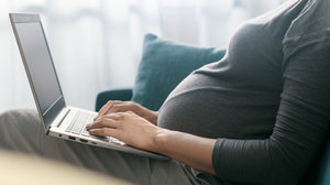 Expecting mother working on a laptop.