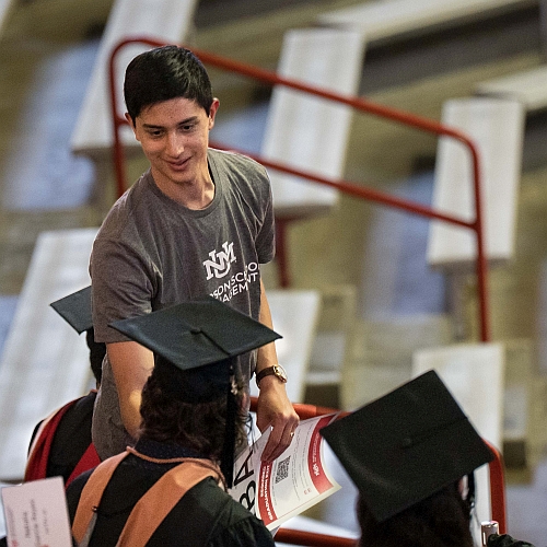 Michael Martinez assists students at UNM Anderson Convocation