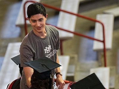 Staff helps students navigate the graduation ceremony at UNM Anderson