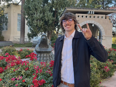 Image of Britten Ratcliff in front of lobo statue near Hodgin Hall.